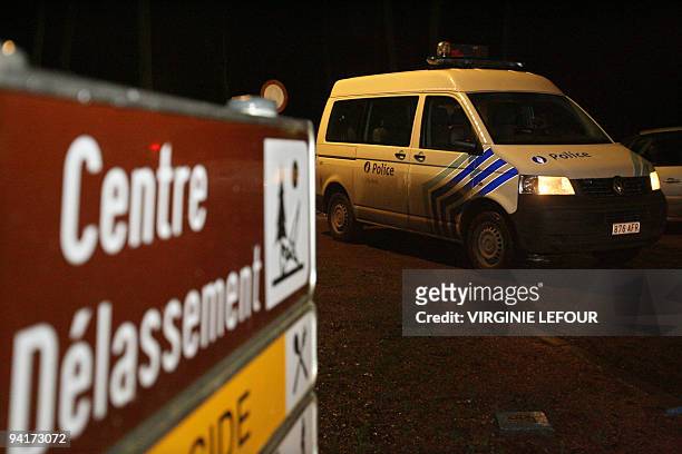 Police car passes a sign indicating a rest stop in Marcinelle on December 9, 2009. The search for the body of five-year-old Typhaine continues in the...