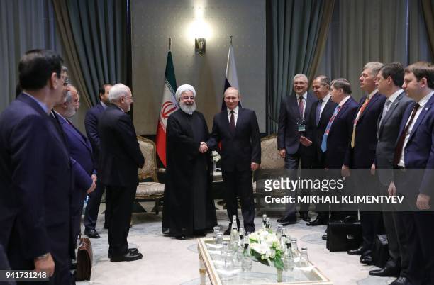 Russian President Vladimir Putin shakes hands with Iranian President Hassan Rouhani during a meeting in Ankara on April 04, 2018.