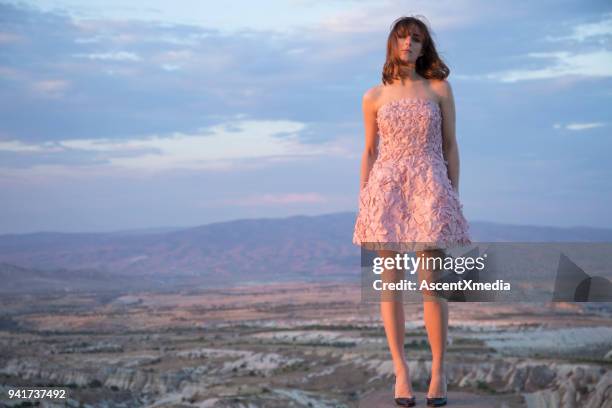 jonge vrouw op dak in roze jurk boven cappadocië. - zachtroze stockfoto's en -beelden