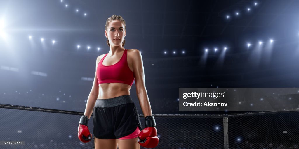 Female MMA fighter in professional boxing ring