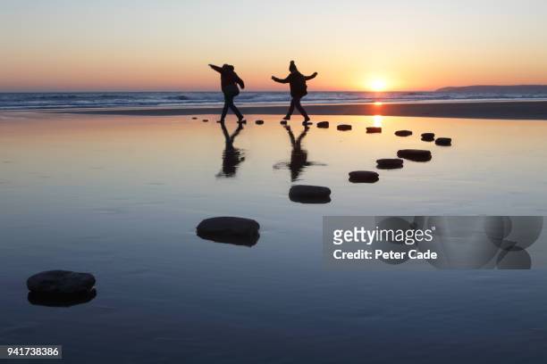 stepping stones over water, two people - legame affettivo foto e immagini stock