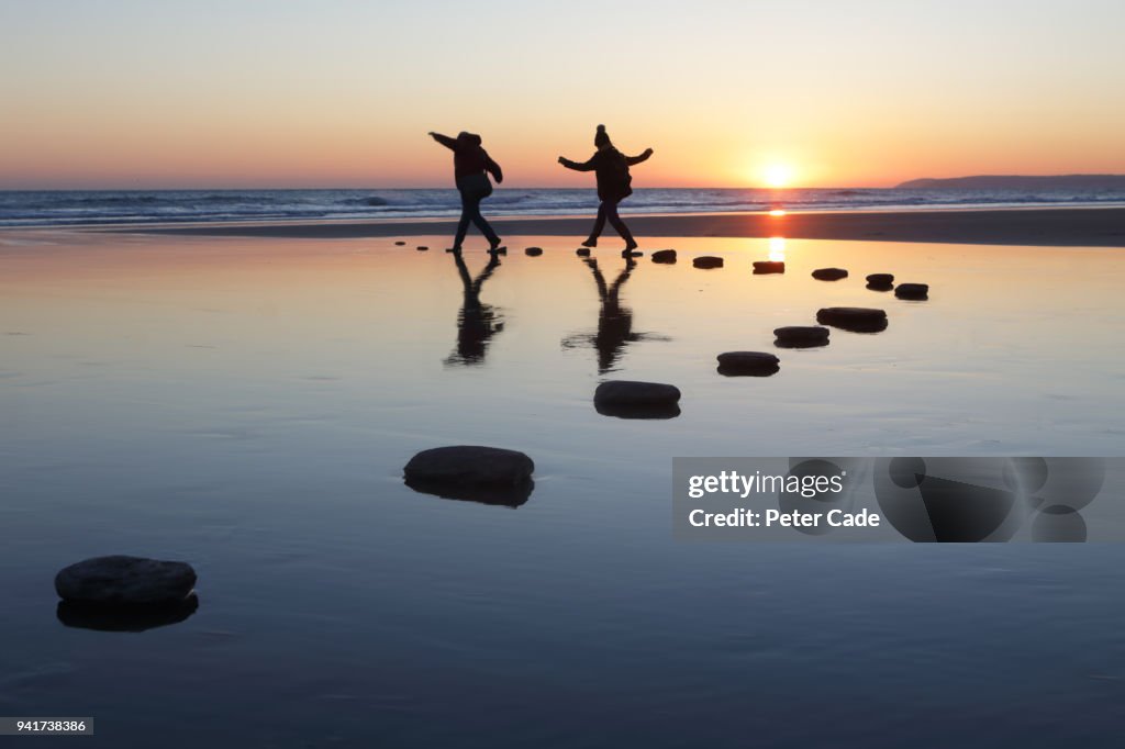 Stepping stones over water, two people