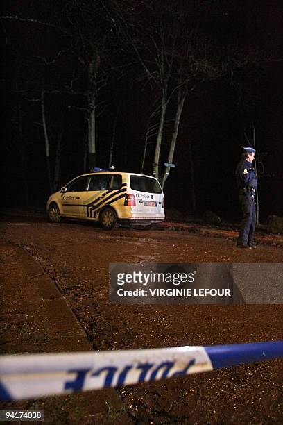 Policeman stands guard in the aera where police continues the research for the body of five-year-old Typhaine on December 9, 2009 in the woods near...