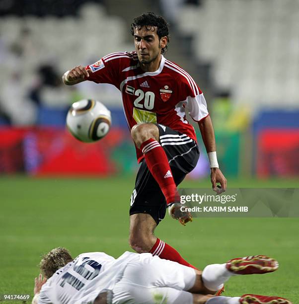 Yussef Jaber of the Emirati Al-Ahli team tries to kick the ball as Auckland's Jason Hayne falls on the ground during their FIFA Club World Cup match...