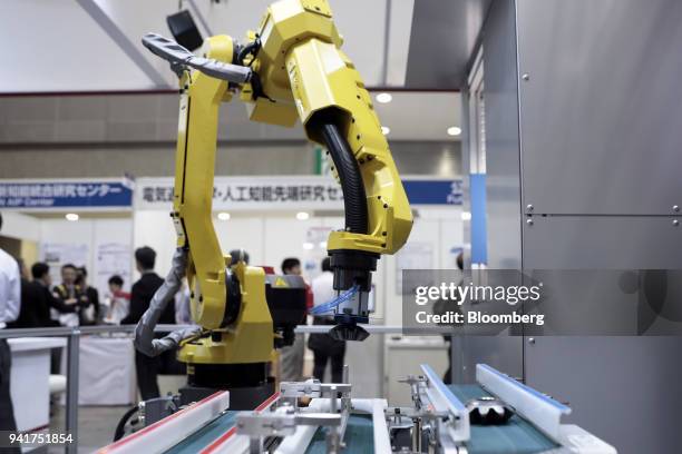 Fanuc Inc. Robotic arm demonstrates the AI system developed by Musashi Seimitsu Industry Co. And Abeja Inc. At the Artificial Intelligence Exhibition...