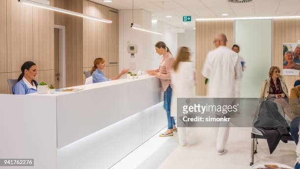 médicos en clínica - receptionist fotografías e imágenes de stock