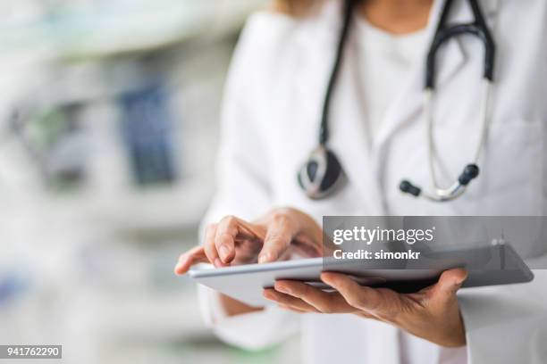 arts met behulp van digitale tablet - doctors equipment stockfoto's en -beelden