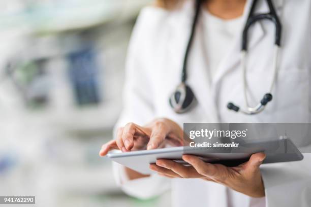 doctor using digital tablet - medical imagens e fotografias de stock