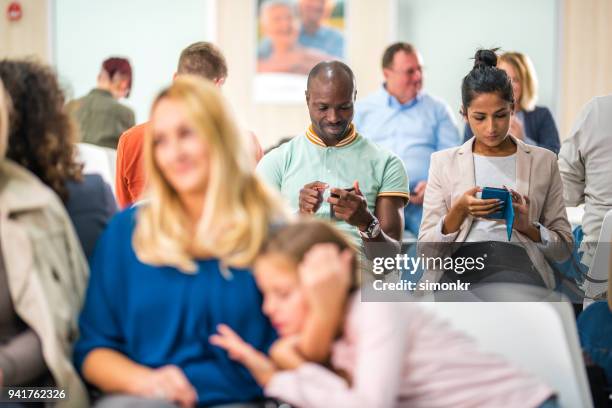 sentado na cadeira na sala de espera de pacientes - waiting room - fotografias e filmes do acervo