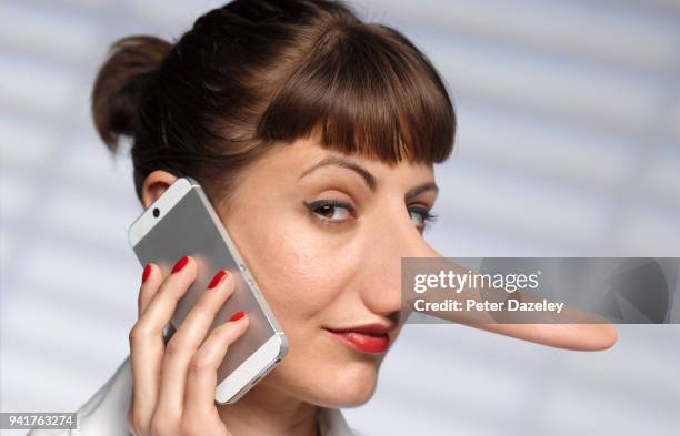 woman telling lies  on mobile phone - adult imitation stock-fotos und bilder