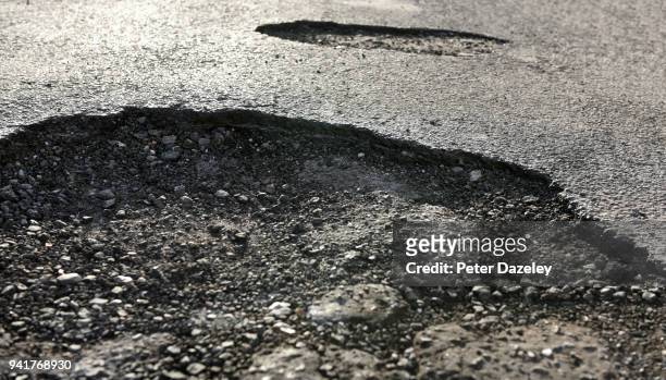 road with dangerous potholes - pothole photos et images de collection
