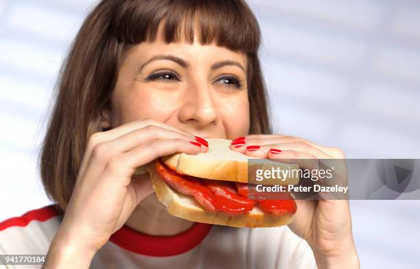 woman eating unhealthy bacon sandwich - carne procesada fotografías e imágenes de stock