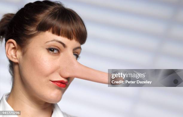 untrustworthy woman with long nose - unehrlichkeit stock-fotos und bilder