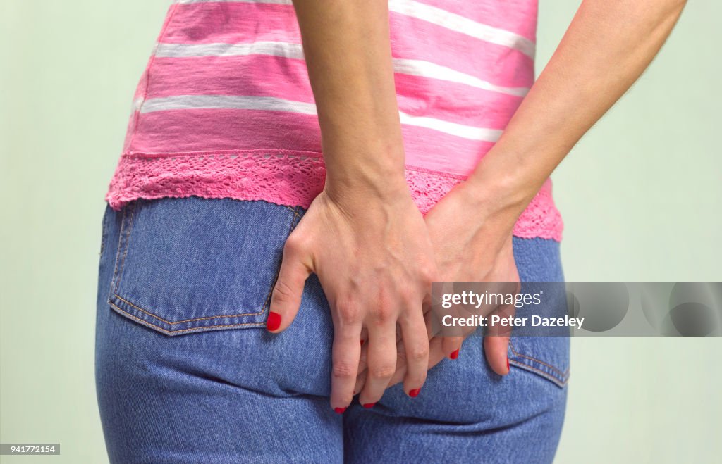 WOMAN CLUTCHING BOTTOM WITH PROBLEMS