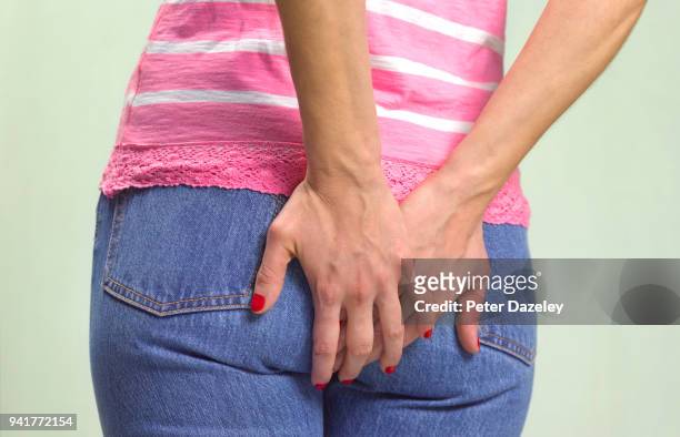 woman clutching bottom with problems - fart imagens e fotografias de stock