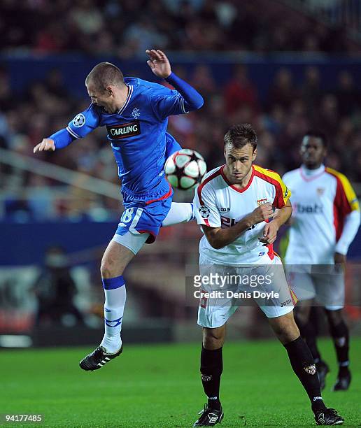 Kenny Miller of Rangers FC goes for a high ball against Fernando Navarro of Sevilla during the UEFA Champions League Group G match between Sevilla...