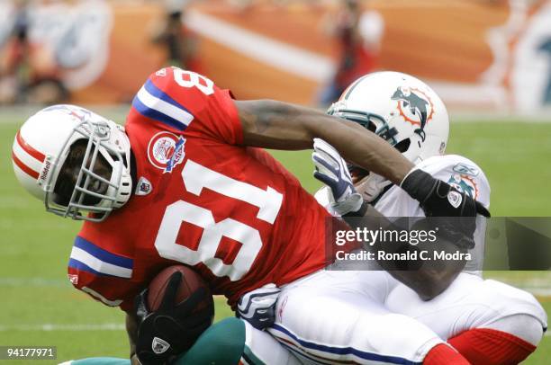 Randy Moss of the New England Patriots is tackled after catching a pass during a NFL game against the Miami Dolphins at Land Shark Stadium on...