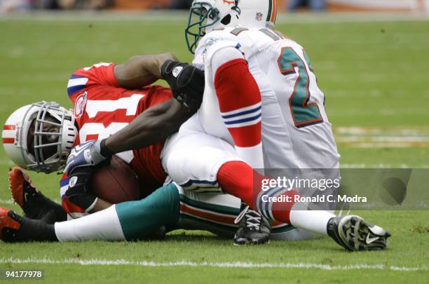 Randy Moss of the New England Patriots is tackled after catching a pass during a NFL game against the Miami Dolphins at Land Shark Stadium on...