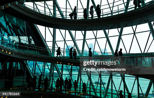 Abstrakte moderne Architektur und Silhouetten von Menschen auf Wendeltreppe Abstrakte moderne Architektur und Silhouetten von Menschen auf Wendeltreppe