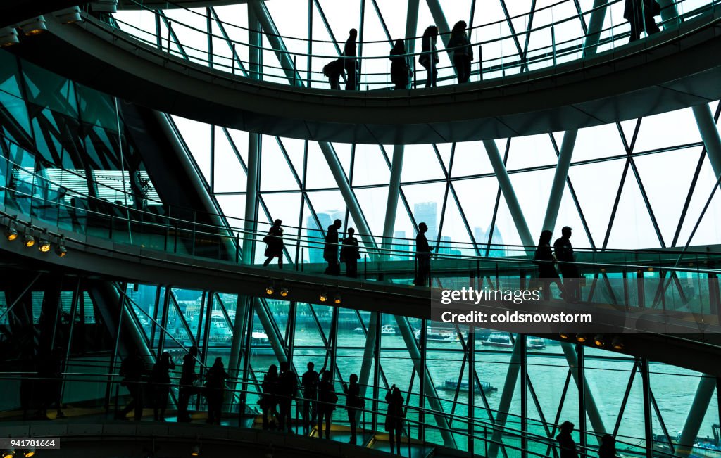 Abstract modern architecture and silhouettes of people on spiral staircase