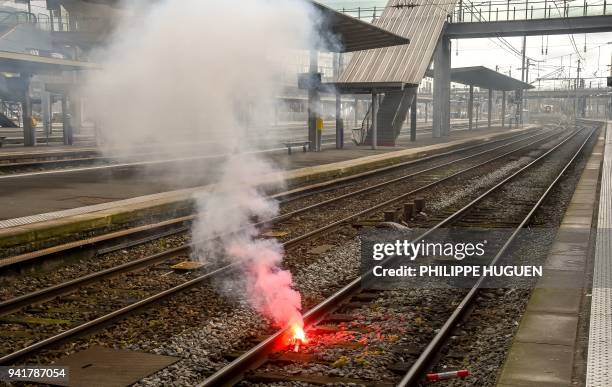 Flare smokes between railway tracks at Lille Flandres Station in Lille on April 4 on the second day of a strike by railway workers. - Millions of...