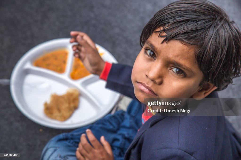 Portrait of Girl kid having mid-day meal in Indian school.