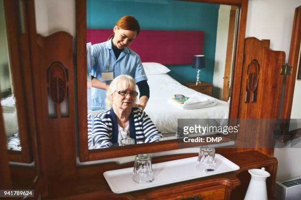 Healthcare worker combing hair of a senior female patient