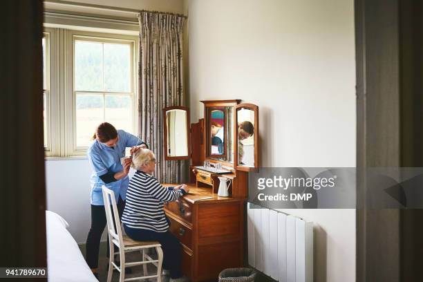 sjuksköterska klä håret på en äldre kvinna - hospice bildbanksfoton och bilder