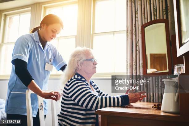 Female caregiver doing senior woman's hair
