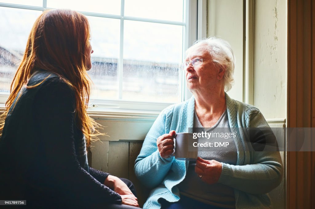 Old woman talking with her young daughter at home
