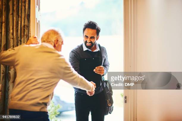 senior man welcoming a healthcare worker - home visit - visit stock pictures, royalty-free photos & images