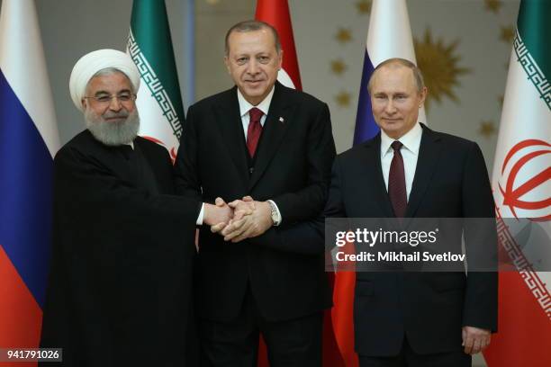 Russian President Vladimir Putin , Turkish President Recep Tayyip Erdogan and Iranian President Hassan Rouhani pose for a photo during their meeting...