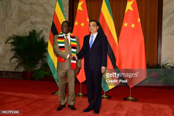 Zimbabwean President Emmerson Mnangagwa shakes hands with Chinese Premier Li Keqiang before their meeting at the Great Hall of the People on April 4,...