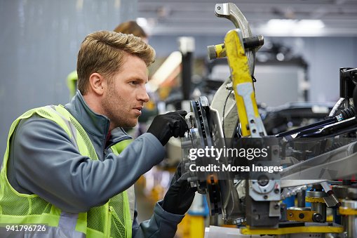 Zuversichtlich männlichen Ingenieur prüft Auto-chassis Zuversichtlich männlichen Ingenieur prüft Auto-chassis