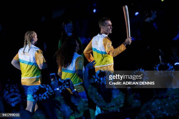 Australian cyclist cyclist Brad McGee carries the Queen's Baton in the opening ceremony of the 2018 Gold Coast Commonwealth Games at the Carrara...