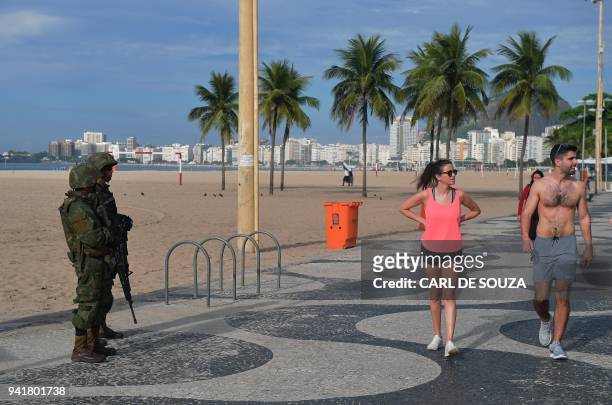 Brazilian soldiers patrol at Copacabana beach in Rio de Janeiro on April 4, 2018. Military operations against drug gangs have increased in regularity...