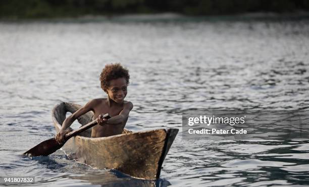 pacific island child in homemade canoe - einbaum stock-fotos und bilder
