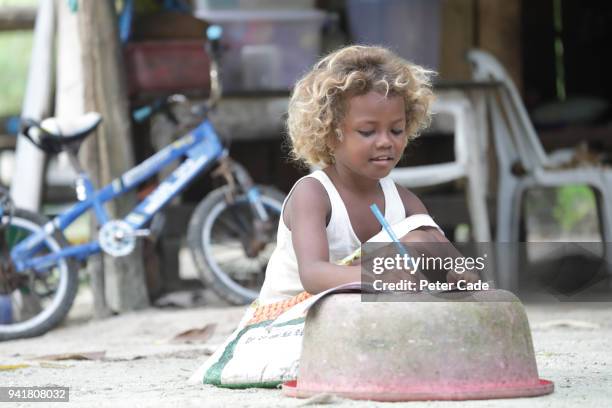 pacific island child doing homework - washing tub stockfoto's en -beelden