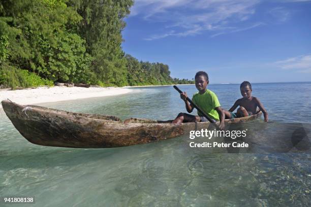 pacific island children in homemade canoe - papuma beach stock pictures, royalty-free photos & images