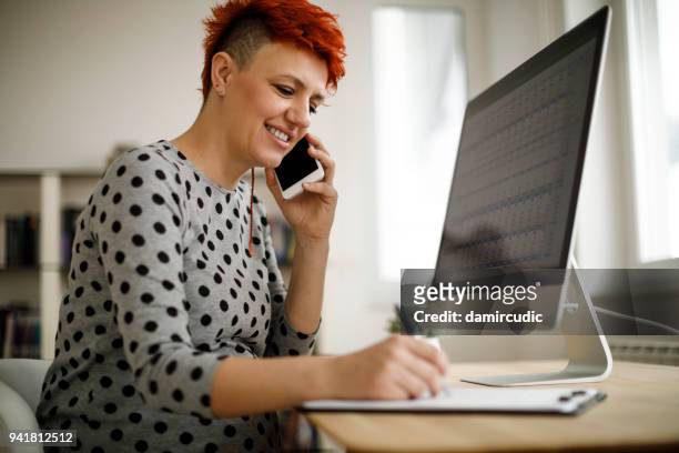 zwangere vrouw werken vanuit kantoor aan huis - woman filling out paperwork stockfoto's en -beelden