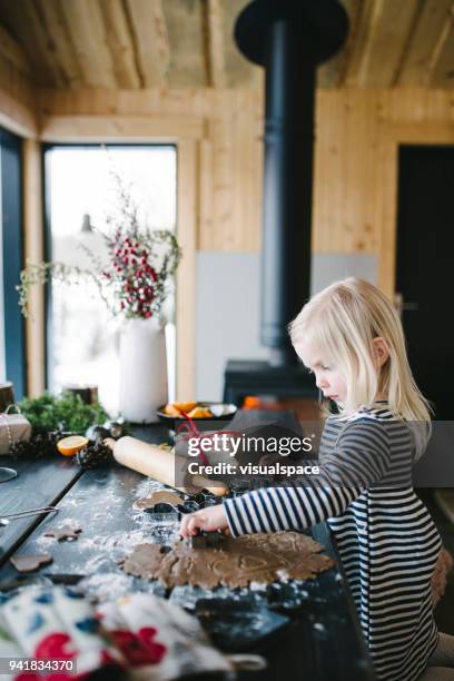 cute nordic little girl making gingerbread cookies - christmas scandinavia stock pictures, royalty-free photos & images