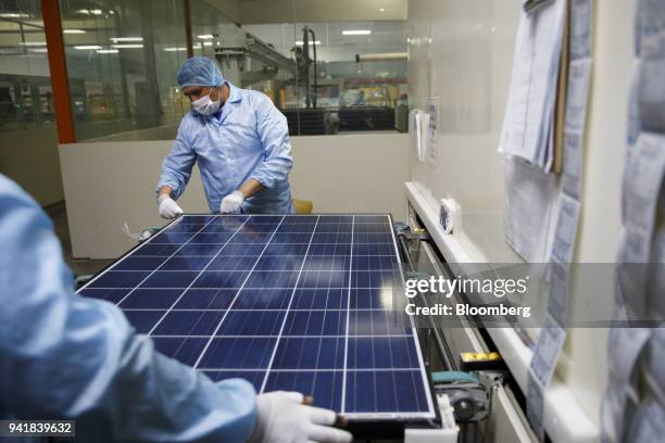 Workers prepare a solar panel for packaging during production at the SunSpark Technology Inc. Manufacturing facility in Riverside, California, U.S.,...