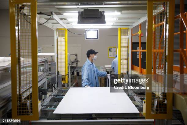 Worker performs a quality control test during solar panel production at the SunSpark Technology Inc. Manufacturing facility in Riverside, California,...