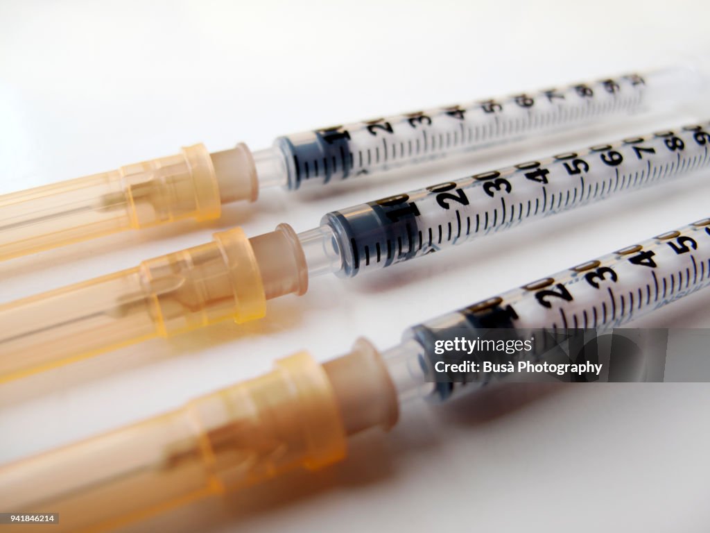 Three ultra-fine insulin syringes on white background