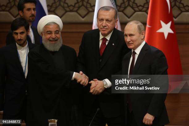 Russian President Vladimir Putin , Turkish President Recep Tayyip Erdogan and Iranian President Hassan Rouhani pose for a photo during their meeting...
