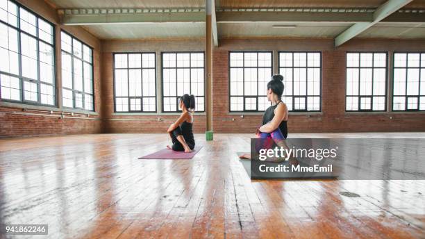 women practicing yoga. teaching spinal twist pose. ardha matsyendrasana - spinal twist stock pictures, royalty-free photos & images