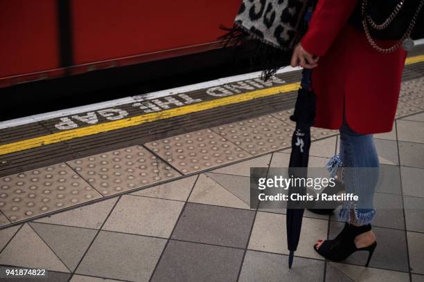 Woman waits for an underground train at Bank station as the deadline nears for companies to report their gender pay gap on April 4, 2018 in London,...