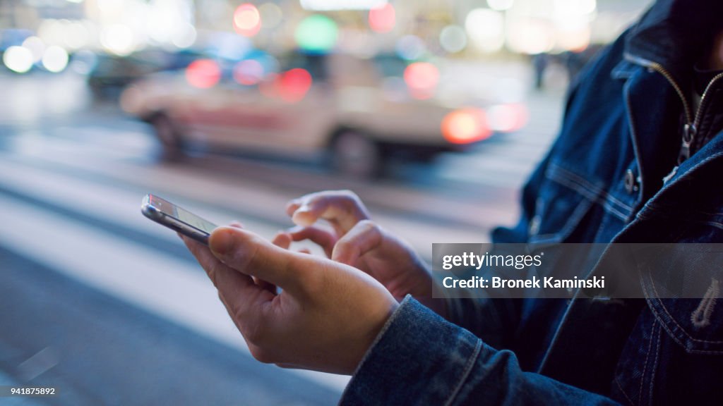 A man uses a mobile phone at Shibuya crossing