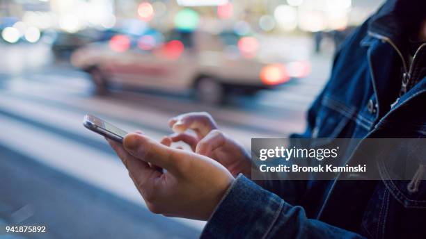 a man uses a mobile phone at shibuya crossing - hand person photos et images de collection