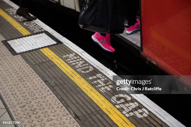 Woman boards an underground train at Bank station as the deadline nears for companies to report their gender pay gap on April 4, 2018 in London,...